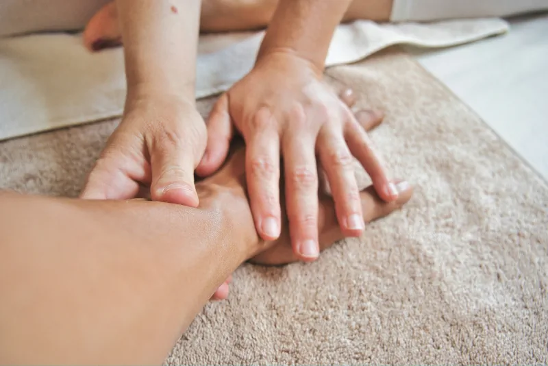 Therapist performing a hand massage on a client